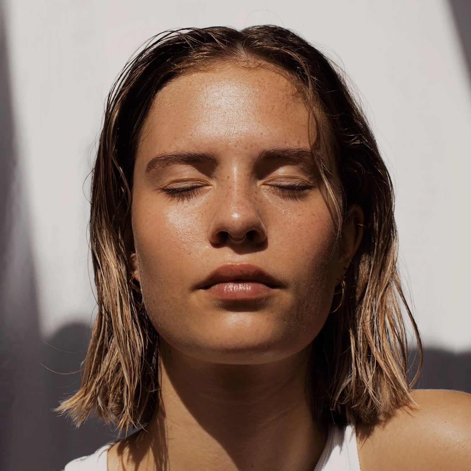 Woman enjoying sunlight with calm expression, representing Seb calming serum benefits for soothing sensitive, eczema-prone skin